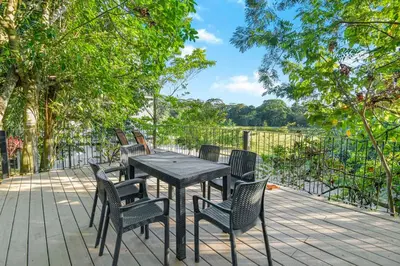 a black table and chairs on a deck with trees at Arcadia Condo In Místico, Playa Hermosa in Playa Hermosa
