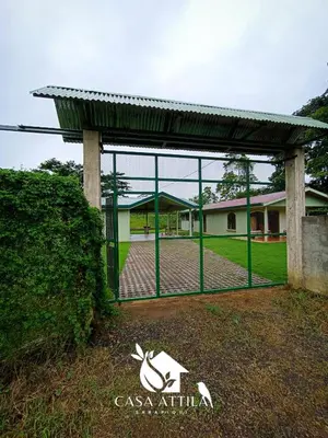 a gate with a fence in front of a house at Casa Attila Sarapiquí in Sarapiquí