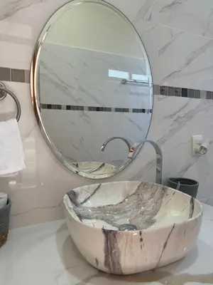 a bathroom with a marble sink and a mirror at Chilamate Room 2 in Tortuguero