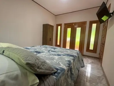 a bedroom with a bed in a room with windows at Chilamate Room 2 in Tortuguero