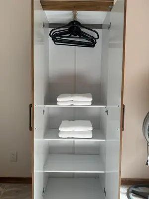 a white closet with white towels on shelves at Chilamate Room 2 in Tortuguero