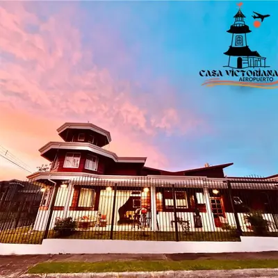 a building with a lighthouse in the background at Casa Victoriana Aeropuerto in San Juan Arriba