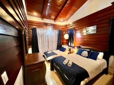 a bedroom with two beds with blue pillows at Casa Victoriana Aeropuerto in San Juan Arriba