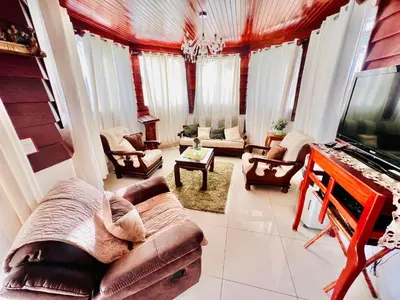 a living room with a couch and a tv at Casa Victoriana Aeropuerto in San Juan Arriba