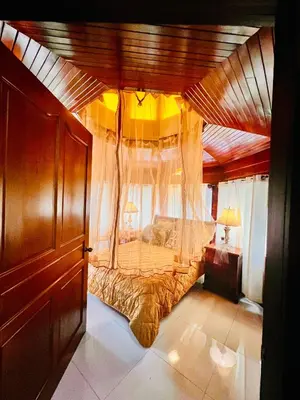a bedroom with a large canopy bed with curtains at Casa Victoriana Aeropuerto in San Juan Arriba