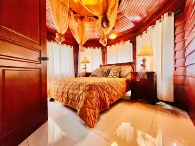 a bedroom with a bed in a room with curtains at Casa Victoriana Aeropuerto in San Juan Arriba