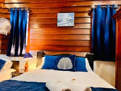 a bedroom with a bed with blue curtains at Casa Victoriana Aeropuerto in San Juan Arriba
