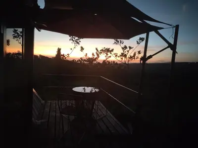 a table and chairs and an umbrella at sunset at Vistas Paraiso San Carlos in Venecia