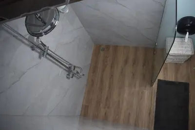 a bathroom with a marble shower with a wooden floor at Vistas Paraiso San Carlos in Venecia