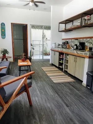 a living room with a table and a kitchen at Casa IGUANA in Santa Teresa Beach