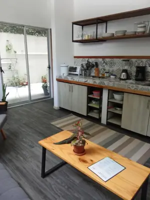 a living room with a table and a kitchen at Casa IGUANA in Santa Teresa Beach