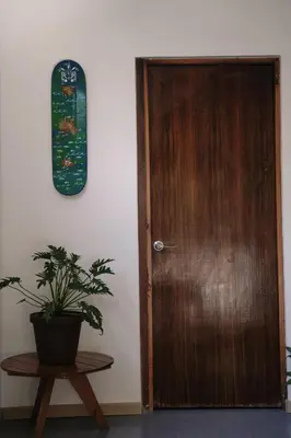 a wooden door with a potted plant next to a table at Casa IGUANA in Santa Teresa Beach