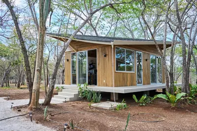 a tiny house in the woods with trees at SURÁ Playa Negra in Playa Negra