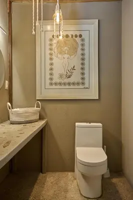 a bathroom with a toilet and a picture on the wall at SURÁ Playa Negra in Playa Negra