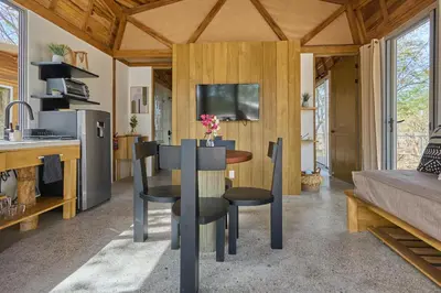 a kitchen and living room with a table and chairs at SURÁ Playa Negra in Playa Negra