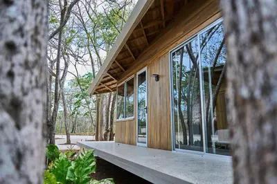 a house in the woods with large windows at SURÁ Playa Negra in Playa Negra