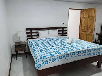 a bedroom with a bed with a blue and white blanket at Bernis House with Jacuzzi in Tanque