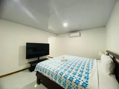 a bedroom with a bed and a flat screen tv at Bernis House with Jacuzzi in Tanque