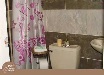 a bathroom with a toilet and a shower curtain at Private rooms, 10 min from SJO Airport in Ciudad Cariari