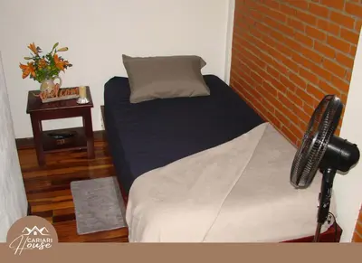a bedroom with a bed and a brick wall at Private rooms, 10 min from SJO Airport in Ciudad Cariari