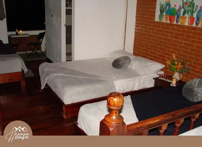 a bedroom with two beds and a brick wall at Private rooms, 10 min from SJO Airport in Ciudad Cariari