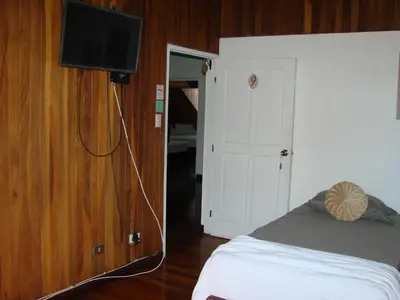 a bedroom with a bed and a flat screen tv at Private rooms, 10 min from SJO Airport in Ciudad Cariari