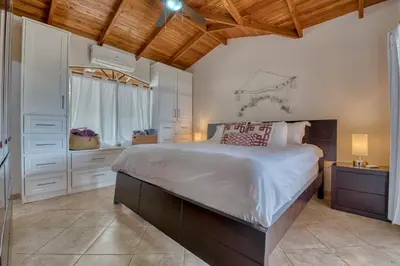 a bedroom with a large bed and a window at The Retreat at Blue Mountain Farms in Sámara