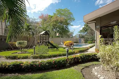 a garden with a playground and a slide at Pitaya Lodge in Potrero