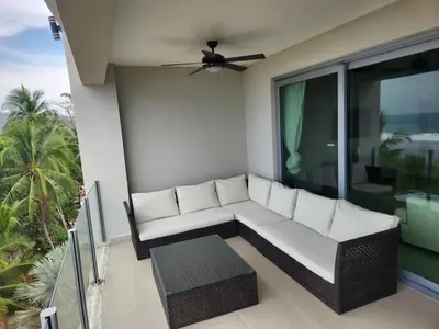 a couch sitting on the balcony of a house at Diamante del Sol- 2 BR- Beach Front- Jaco in Jacó