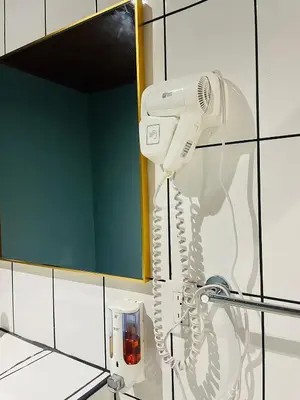 a white hairdryer hanging on a wall in a bathroom at El Castillo Harmony in El Castillo de La Fortuna