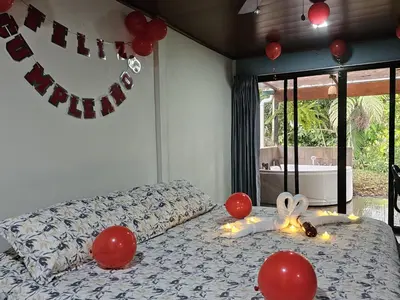 a bedroom with a bed with red balloons on it at El Castillo Harmony in El Castillo de La Fortuna