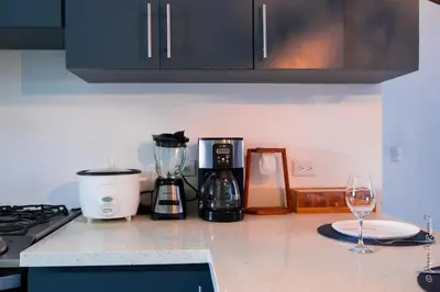 a kitchen counter with a blender and a wine glass at Casa Plomo - 10 bed, 5 bdrm - One Block from Clubs in Jacó