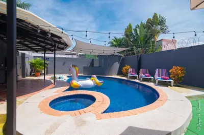 a swimming pool with a inflatable pool toy in a backyard at Casa Plata & Casa Plomo in Jacó