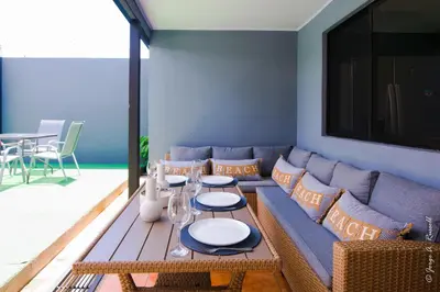 a living room with a blue couch and a table at Casa Plata & Casa Plomo in Jacó