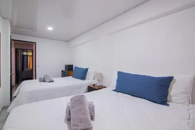 a bedroom with two beds with blue pillows at Casa Plata & Casa Plomo in Jacó