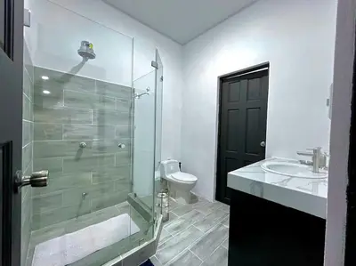 a bathroom with a glass shower and a toilet at Casa Plata & Casa Plomo in Jacó