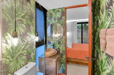 a bathroom with a shower with tropical wallpaper at Luxury 2BR condo in Nautilus, Místico in Parrita