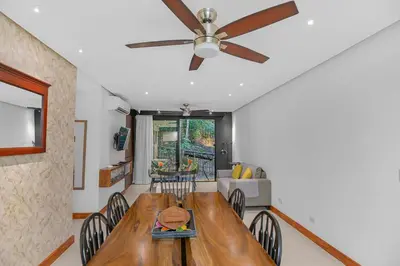 a dining room with a wooden table and a ceiling fan at Luxury 2BR condo in Nautilus, Místico in Parrita