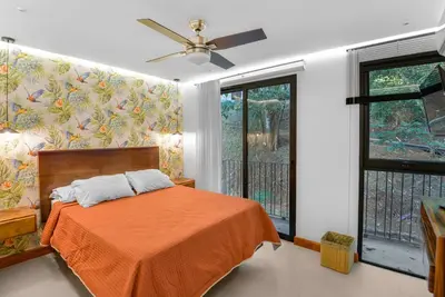 a bedroom with a bed with an orange blanket at Luxury 2BR condo in Nautilus, Místico in Parrita