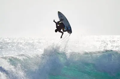 a man riding a wave on a surfboard in the ocean at Ola Bonita BeachFront Apart Hotel in Playa Hermosa