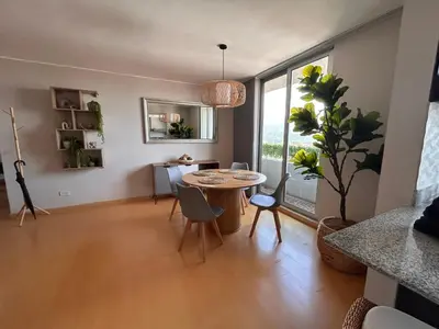 a living room with a table and a large window at Moderno apartamento totalmente equipado in San José