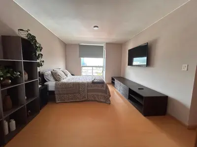 a bedroom with a bed and a tv on the wall at Moderno apartamento totalmente equipado in San José