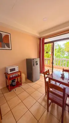 a kitchen with a table and a stainless steel refrigerator at Hotel Beachfront Vista Hermosa in Jacó