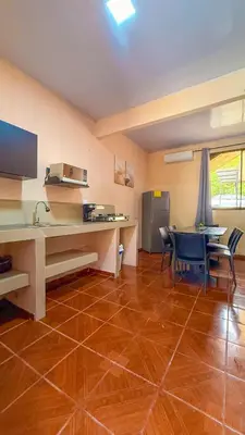 a room with a desk and a kitchen with a table and chairs at Hotel Beachfront Vista Hermosa in Jacó