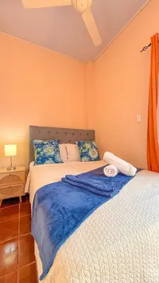 a bedroom with two beds with blue and white sheets at Hotel Beachfront Vista Hermosa in Jacó