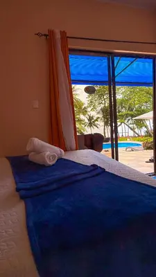 a bedroom with a bed with a view of the beach at Hotel Beachfront Vista Hermosa in Jacó