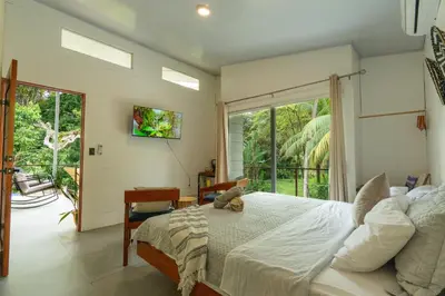 a bedroom with a bed and a large window at Casa Jalapa with private pool in Uvita