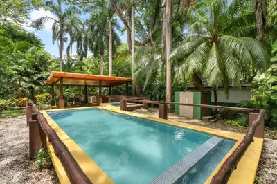 a swimming pool with a gazebo and trees at Spacious 3-Bedroom Coastal Home with Shared Pool, Outdoor Living & Steps to Playa Potrero in Potrero