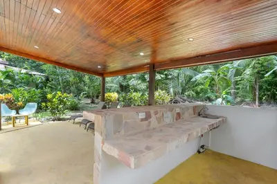 a large patio with a stone bench in the middle at Spacious 3-Bedroom Coastal Home with Shared Pool, Outdoor Living & Steps to Playa Potrero in Potrero