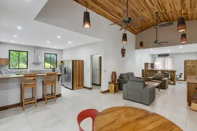 an open kitchen and living room with a wooden ceiling at Spacious 3-Bedroom Coastal Home with Shared Pool, Outdoor Living & Steps to Playa Potrero in Potrero